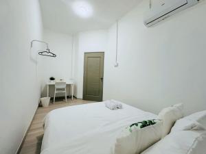 a white bedroom with a white bed and a table at 7Pax BM大山脚 Singlestorey Alma 8minute to Aeon mall in Bukit Mertajam