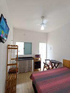 a bedroom with a bed and a flat screen tv at Villa Makai Flats Maresias in Maresias