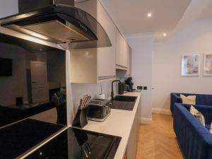a kitchen with a stove top oven next to a living room at The Salisbury sleeps 4 Classic Apartment in Scarborough +20 photos