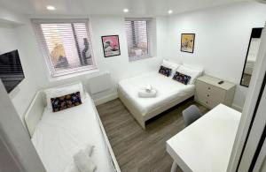 a small white room with a bed and a table at Charlotte Street Rooms by News Hotel in London
