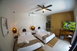 Un dormitorio con dos camas y un televisor de pantalla plana. en Sélanna, en El Paredón Buena Vista
