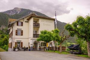 a large white building with a mountain in the background at Hotel Grischuna Filisur in Filisur +18 photos