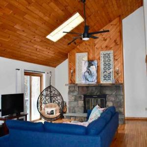 un soggiorno con un divano blu e un camino di Private 3 Bedroom Cottage 5 minutes to Belleayre a Fleischmanns