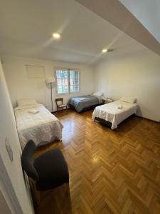 Una habitación con dos camas y una silla dentro. en Casa Bella Mendoza, en Mendoza