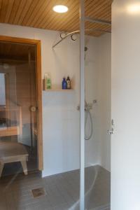 a shower with a glass door in a bathroom at Architectural townhouse with sauna and patio in Helsinki
