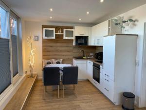 a kitchen with a table and a white refrigerator at Deichnähe C in Norddeich