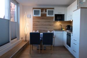 a kitchen with a table and two chairs in it at Deichnähe C in Norddeich