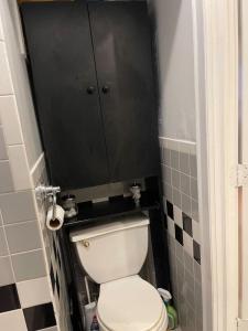 a bathroom with a white toilet and a black wall at 528a) Luxury city condo in New York