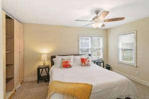 a bedroom with a bed with a ceiling fan and windows at Downtown Libertyville Duplex Near Naval Base in Libertyville