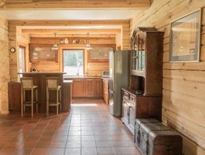 a kitchen in a log cabin with a refrigerator at Rubikių Kranto Sodyba in Anykščiai