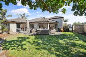 a house with a yard with a house at Luxury and Location Beautiful Beach Home in Papamoa