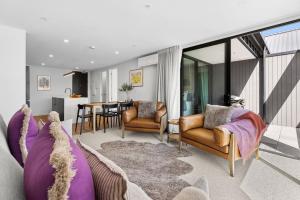 a living room with a couch and chairs and a table at Mountainview Escape | Stylish, BBQ, and Parking in Wanaka