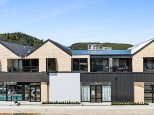 a large house with a black roof at Mountainview Escape | Stylish, BBQ, and Parking in Wanaka