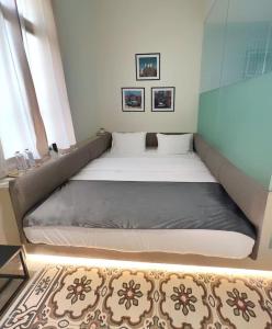 Cama grande en habitación pequeña con ventanas en Bhub Room 204 in Gemmayze, en Beirut