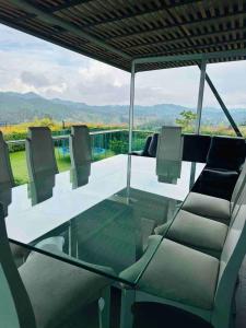 a glass table and chairs with a view of the mountains at Country house near the airport and Medellin in El Retiro