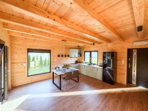 a kitchen and dining room of a log cabin at Na skraju lasu in Rydzewo