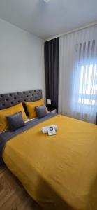 ein Schlafzimmer mit einem gelben Bett mit einem Buch darauf in der Unterkunft Heli Zlatibor in Zlatibor + 29 Fotos