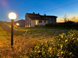a white house on a hill with a street light at Oltrella Country House in Ponte Nizza
