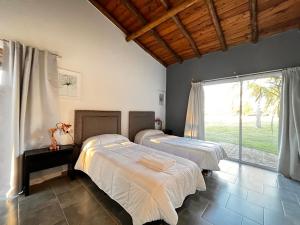 a bedroom with two beds and a large window at Brisas de Brandsen, Chacras con estilo in Loma Verde +192 photos