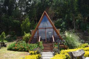a small cabin in a garden with flowers at Aldea Fuquenense in Fúquene