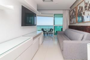una sala de estar con un sofá y un televisor en Apartment Ocean View, en Río de Janeiro