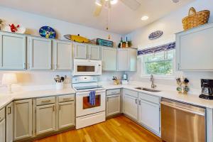 a kitchen with white cabinets and white appliances at Trudy's Treasure in Tybee Island