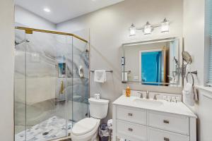 a bathroom with a shower and a toilet and a sink at Trudy's Treasure in Tybee Island +25 photos