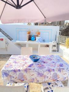 a table and chairs with a table and a pink umbrella at La dolce dimora in Alessano
