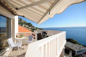 Un balcón con sillas y vista al mar. en Villa Roko, en Omiš