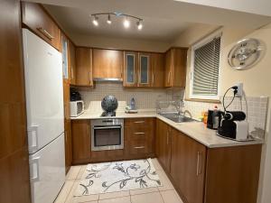 a kitchen with wooden cabinets and a white refrigerator at Апартамент ГТ in Plovdiv