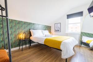 a bedroom with a large bed with a yellow blanket at Bliss Stay Belfast The Mount in Belfast