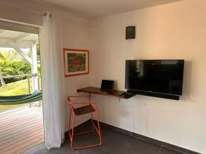 Zimmer mit einem Flachbild-TV an der Wand in der Unterkunft Studio confortable à Petit-Bourg avec terrasse 30 m² in Petit-Bourg
