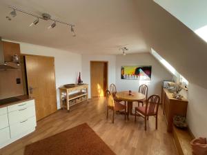 a kitchen and dining room with a table and chairs at Ferienwohnung Körnernest in Ettringen
