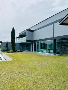 a modern house with a lawn in front of it at Villa near the airport and Medellin in El Retiro