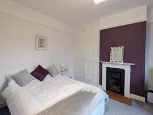 a bedroom with a white bed and a fireplace at Mitton Villa in Stourport