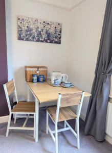 a wooden table with two chairs and a table with a tea set at Mitton Villa in Stourport