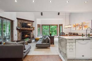 a kitchen and living room with a fireplace at Tremblant Prestige - Manoir 118-10 in Mont-Tremblant +25 photos
