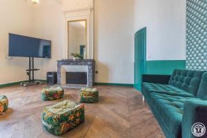 a living room with a green couch and a television at Château de puydaniel in Puydaniel