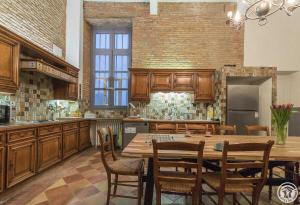 a large kitchen with a wooden table and chairs at Château de puydaniel in Puydaniel +41 photos
