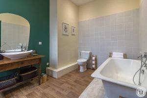 a bathroom with a tub and a sink and a toilet at Château de puydaniel in Puydaniel