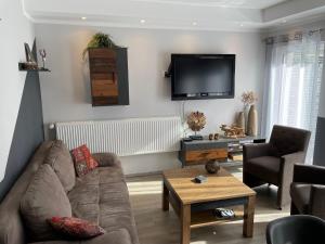 a living room with a couch and a flat screen tv at Apartment Nikki in Medebach +15 photos