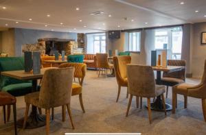 a restaurant with tables and chairs and a fireplace at Sea Breeze Escape in Cubert