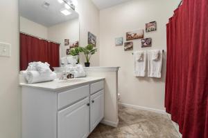a bathroom with a sink and a red shower curtain at CEDAR HEIGHTS 298 in Camdenton +36 photos
