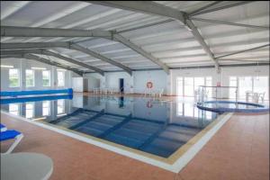 a large indoor swimming pool with blue mats in it at Sea Breeze Escape in Cubert +12 photos