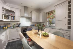 a kitchen with a wooden table and chairs at Dolly's Plaice, Fowey in Fowey