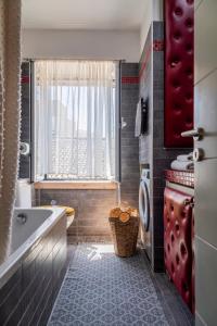 a bathroom with a tub and a toilet and a window at Artist Loft in Corfu +54 photos