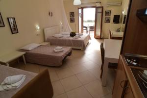 Una habitación de hotel con dos camas y un baño. en Margaritari Hotel, en Agia Anna de Naxos