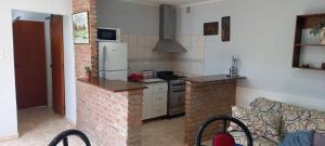 a kitchen with a brick stove and a refrigerator at Departamento cerca de la Basilica de Luján in Luján