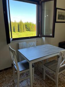 a table and chairs in a room with a window at appartamento Il Galletto in Vitiano +19 photos
