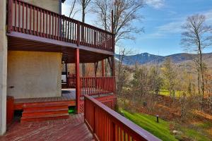 a room with a bed on a deck with a view at Beartopia- Hot Tub, Views, 2 Primary Suites! in Killington
